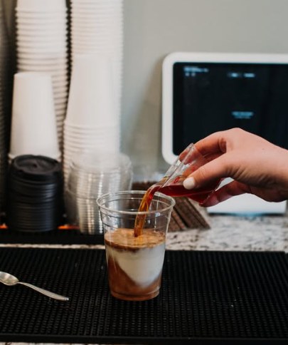 Barista building an iced latte at Meme’s Cafe
