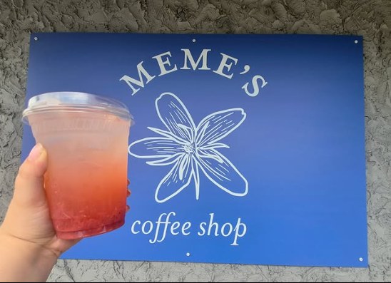 Meme’s Coffee Shop sign with a colorful iced drink