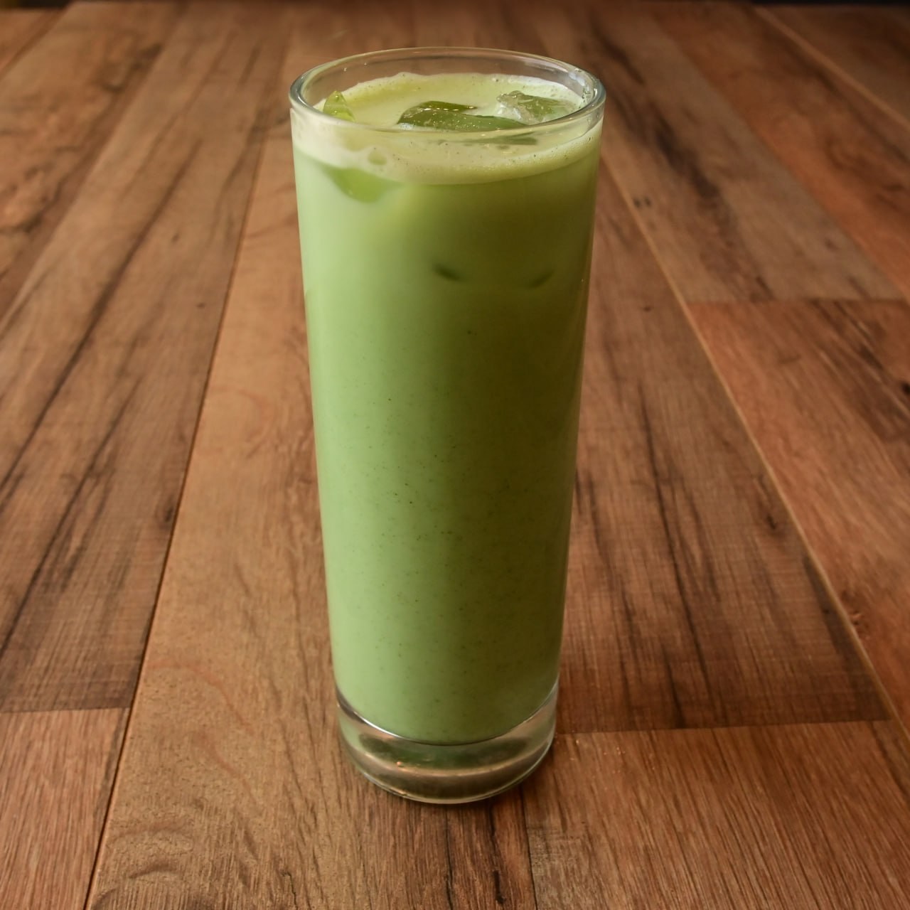 Iced matcha latte on a wood table at Meme’s Cafe
